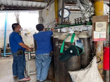 A group of men working in a factory

Description automatically generated